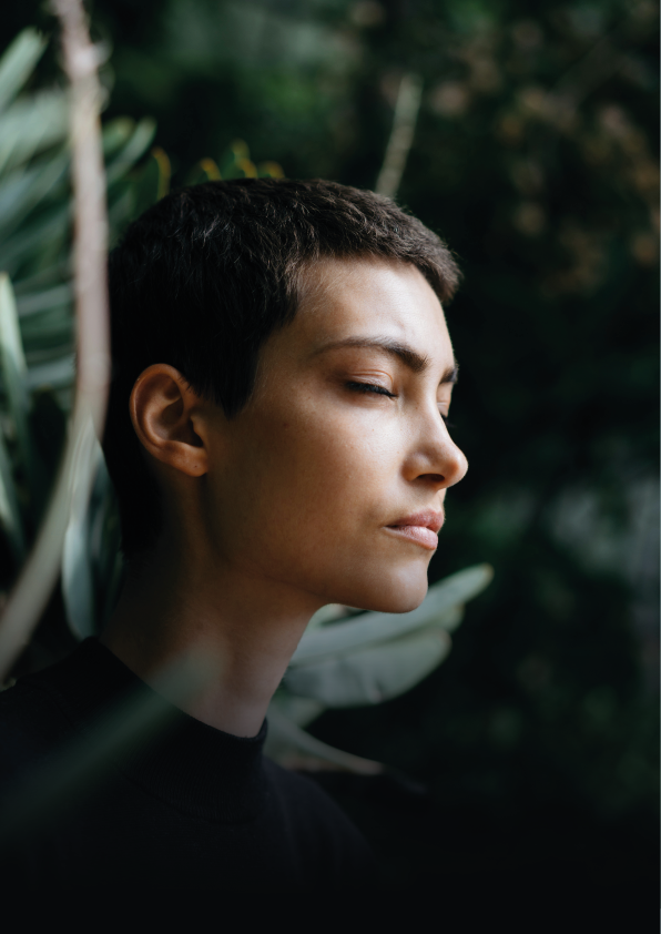Image of woman in front of plants and leaves